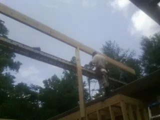 Carpenter setting a ridge beam over a new addition frame — Ice Dam Removal by Roofing Brothers in South Vienna