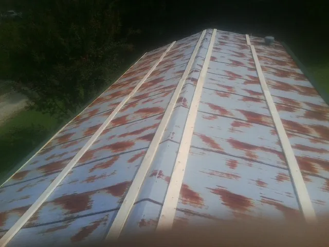 Rusted metal roof panels with new wood purlins before replacement — Storm Damage Roof Repair in South Vienna by Roofing Brothers