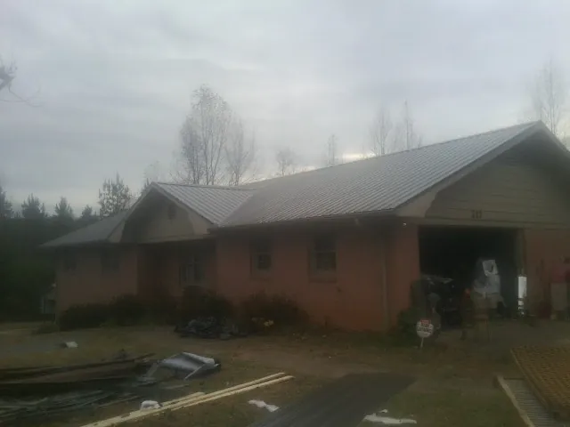 Gray metal roof on a stucco house with an attached garage in South Vienna