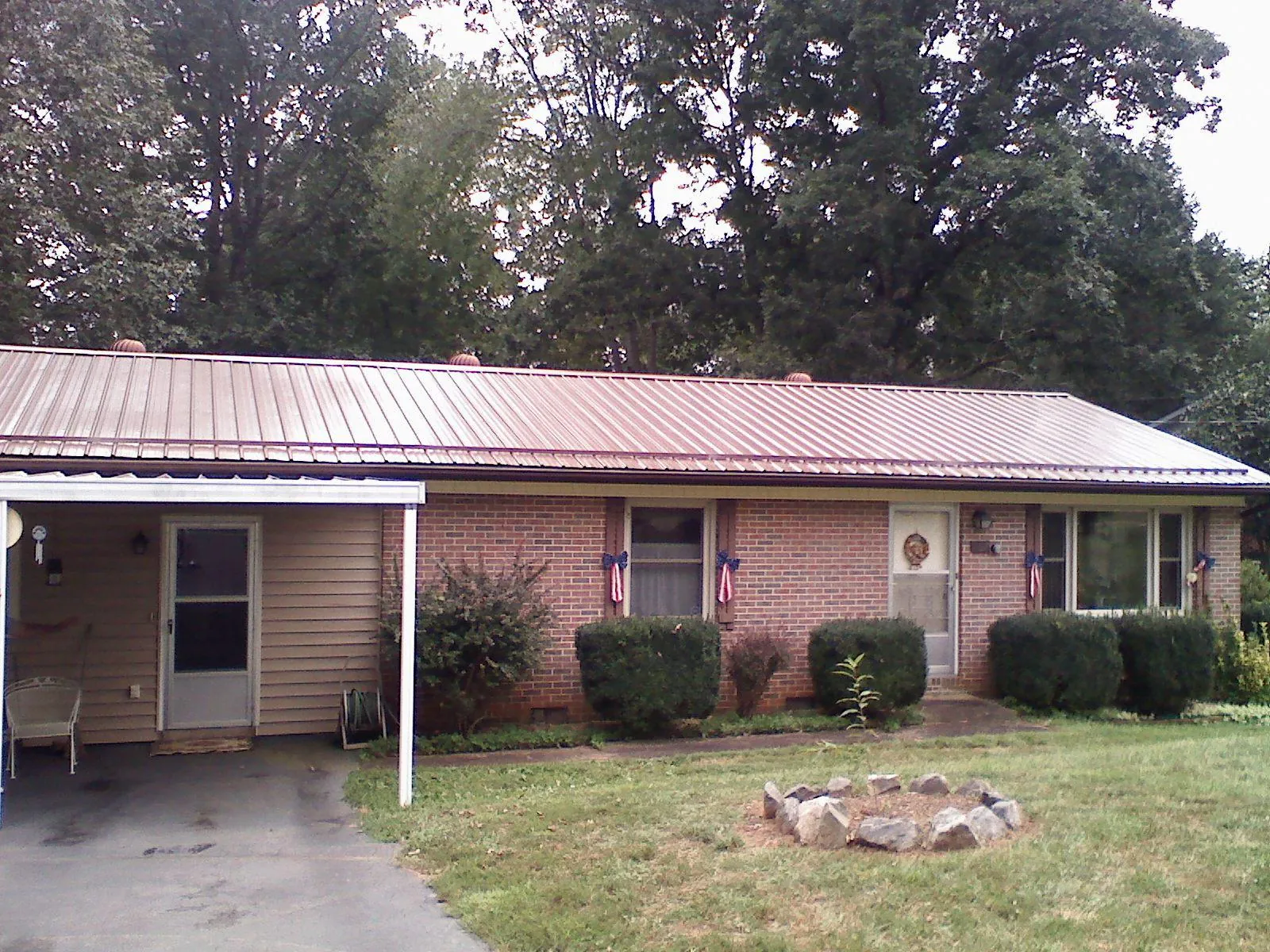 Bronze metal roof and carport on a brick ranch home — Roof Repair work by our crew in South Vienna
