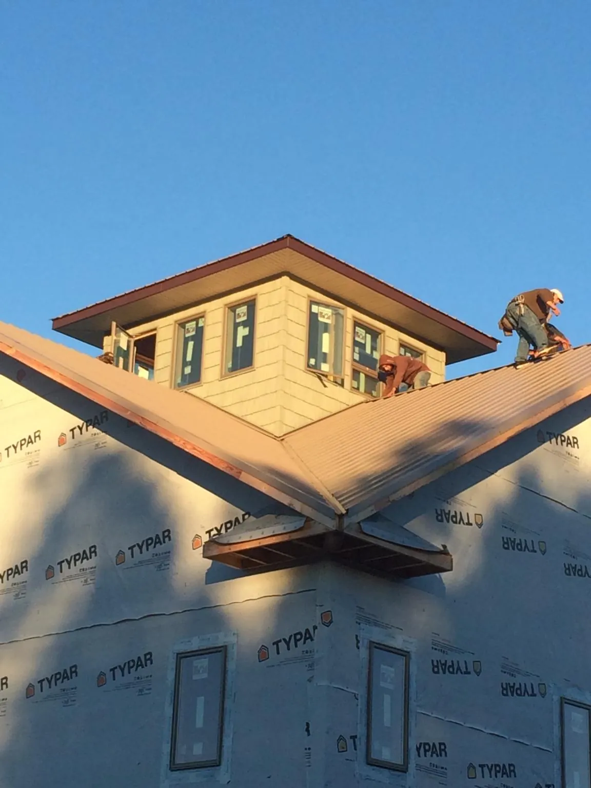 Roofers working around a rooftop cupola on a new metal roof at sunset — Roof Waterproofing in South Vienna by Roofing Brothers